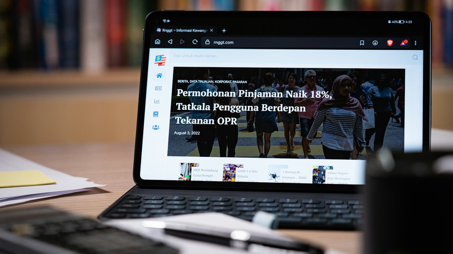 Tablet showing financial news on a keyboard.